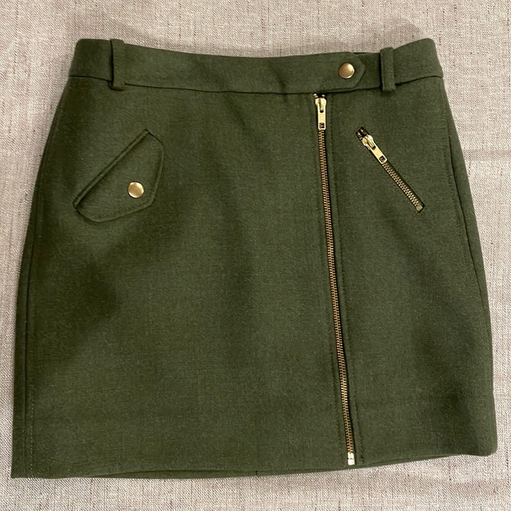 J Crew Olive Green wool skirt. Zip front , gold accents, silk liner. Size 0.
